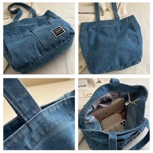 Detail view of large denim tote bag featuring dual front pockets and spacious interior