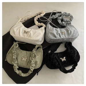 Detailed view of trendy ruched underarm bags with metal butterfly buckles in four colors