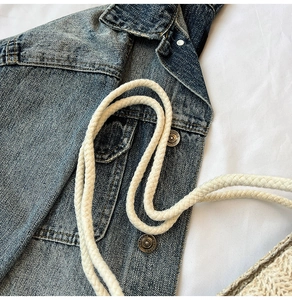 Détail du sac cabas en jean bleu délavé avec bouton métallique et anse en corde