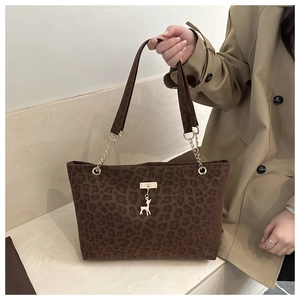 Dettaglio borsa shopper leopardata con ciondolo a cervo dorato e tracolla in catena