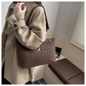 Dettaglio borsa shopper leopardata con tracolla a catena d'oro e ciondolo a cervo