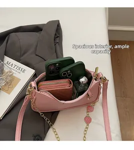 Detail view of pink leather crossbody bag interior holding phones, wallet and perfume