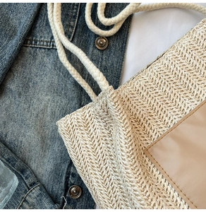 Détail du sac cabas en paille tressée avec bordure en cuir et poignées en corde de coton