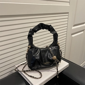 Minimalist black pleated cloud hobo bag with wave handle and decorative metal chain strap