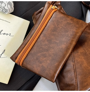 Detail view of brown vintage PU leather small tote with contrast orange zipper design