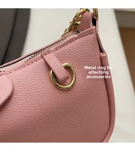 Close-up of pink lychee grain leather handbag with gold D-ring hardware and neat stitching