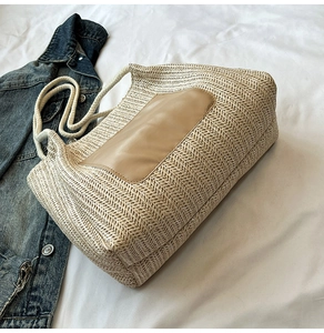 Détail d'un grand sac cabas en paille avec patch en cuir marron et anses en corde souple