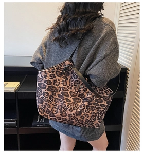 Detail of vintage leopard print tote bag with black leather straps and metal twist lock