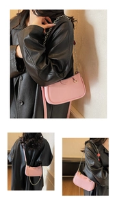 Detailed view of pink crescent bag with gold chain and leather strap on black jacket