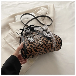 Detailed shot of leopard print handbag with lace trim, bows and metal cross chains