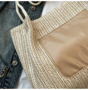 Gros plan du sac cabas en paille tissée avec patch en cuir marron et anses en corde