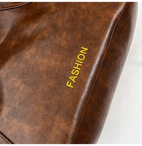 Close-up of brown oiled leather texture with yellow Fashion text on a large tote bag