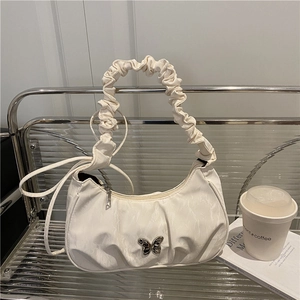 White pleated crescent shoulder bag with ruffle handle and silver butterfly buckle