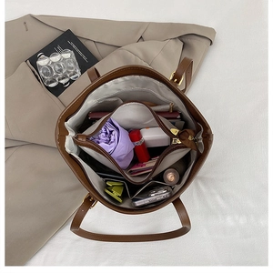 Interior view of brown tote bag showing multi-compartment storage and large capacity