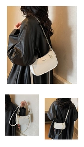 Detail of white half-moon underarm bag with lychee texture and gold chain strap