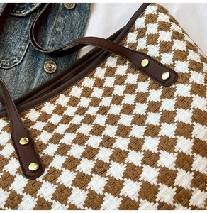 Macro shot of woven tote bag texture with leather handle and gold rivet details