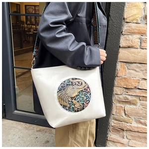 Detail of cream leather tote with ethnic elephant relief and jacquard shoulder strap