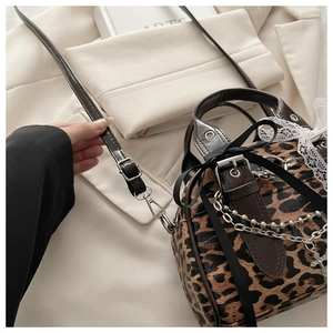 Detail of leopard print crossbody bag with metal cross chain and lace bow decorations