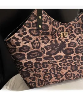 Detail of leopard print tote featuring gold rivets on straps and metal twist lock