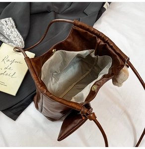 Detail view of large tote bag with inner lining, small pouch, and decorative plush charm