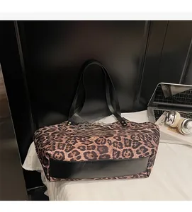 Close-up of leopard print tote bag with black leather base and stylish side rivets