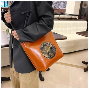 Close-up of vintage orange-brown tote bag featuring a circular elephant relief design