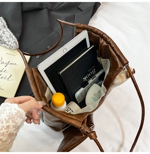 Detailed top view of large brown tote bag showing spacious interior with tablet and books