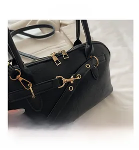 Close-up of black retro shell bag showing PU leather texture and gold hardware details