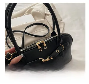 Detail of smooth gold zippers and premium leather texture on a black crossbody bag