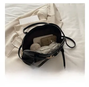 Interior view showing the large capacity of this black leather shell bag for daily essentials