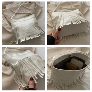 Detail view of white fringe crossbody bag showing magnetic closure and interior storage