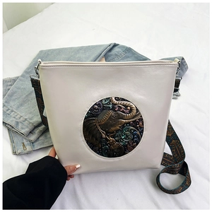 Detail of vintage elephant relief and ethnic printed strap on off-white tote bag