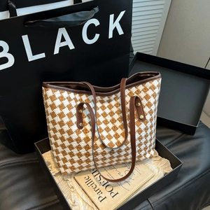 Chic woven tote bag with brown houndstooth pattern and leather handles in a gift box