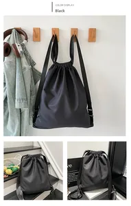Detail of waterproof black drawstring backpack showing matte nylon fabric and strap buckle