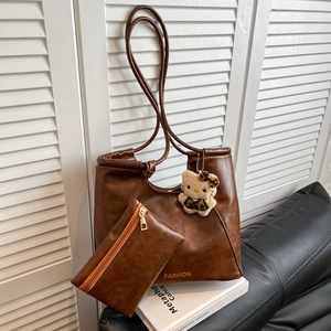Brown vintage leather tote bag with a small wallet and a cute plush kitty charm
