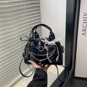 Gothic black patent leather shoulder bag with lace bow and silver cross chain detail