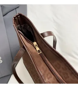 Close-up of golden zipper closure and leopard print matte texture on tote bag