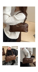 Close-up of brown textured leather shell bag with gold buckle and double zipper details