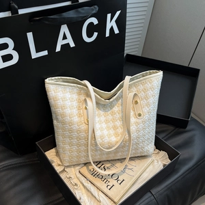 Large woven tote bag with houndstooth texture and leather straps in a black gift box
