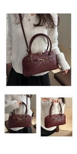 Detail view of burgundy faux leather bag with metal horsebit and adjustable strap