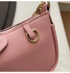 Detail of pink lychee leather shoulder bag with gold hardware and smooth metal zipper