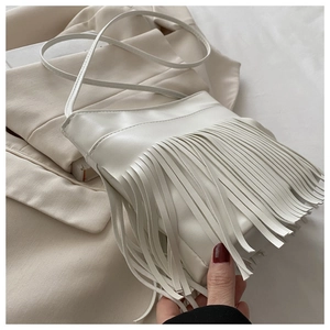 Detailed view of white ethnic fringe handbag with soft synthetic leather texture