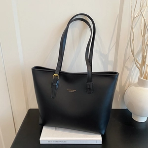 Chic black leather tote bag with gold logo and spacious layered interior for commuting