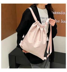 Close-up of pink satin drawstring backpack showing soft glossy fabric and adjustable straps