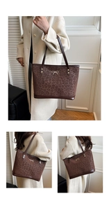 Detail of leopard print tote bag with gold bow ornament and brown leather trim