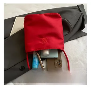 Détails du sac seau rouge en nylon montrant sa capacité de rangement quotidienne