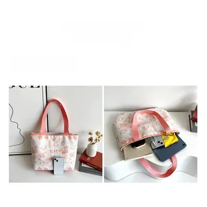 Detail showing the large capacity of the white canvas tote bag with pink straps and bear print