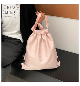 Close-up of pink nylon bucket bag with drawstring closure and dual top handles