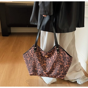 Detailed view of the leopard print tote bag featuring a gold twist lock and black strap