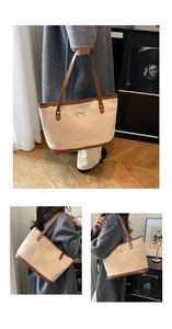 Detail of leopard print tote bag with brown leather handles and golden bow hardware